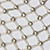 A close-up of a geometric pattern featuring white, diamond-shaped tiles bordered by thin gold lines, creating a repeating grid design.