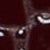 Close-up image of two white, crescent-shaped eyes staring out from a dark, shadowy background, creating a mysterious and intense atmosphere.