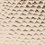 Close-up of corrugated cardboard texture, showing a repeating pattern of small, raised, oval shapes in light brown color.