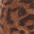 Close-up of a brown and black spotted pattern resembling animal fur, such as that of a leopard or cheetah. The image shows a textured surface with irregular dark spots on a lighter brown background.