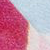 A close-up image showing a textured surface divided diagonally: the left side is filled with a dense pattern of red dots, while the right side has a more sparse pattern of blue and white dots.