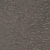 Primo piano di una superficie scura e strutturata con un aspetto maculato, caratterizzato da piccole macchie chiare e scure. La texture ricorda la pietra, lasfalto o il cemento grezzo.
