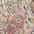 Abstract pattern featuring a mix of leopard spots and paisley designs, with dominant hues of pink, brown, and beige blending together.
