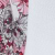 A close-up of a fabric with a red, black, and white floral pattern on the left side, next to a textured white surface on the right.