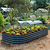 Pacific PC Cloche protecting seedlings in a dark metal raised garden bed in a landscaped garden| Vego Garden
