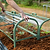 Hands positioning a Pacific PC Cloche over seedlings in a raised garden bed| Vego Garden