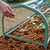 Hand adjusting the circular ventilation opening in the clear end panel of a Pacific PC Cloche| Vego Garden