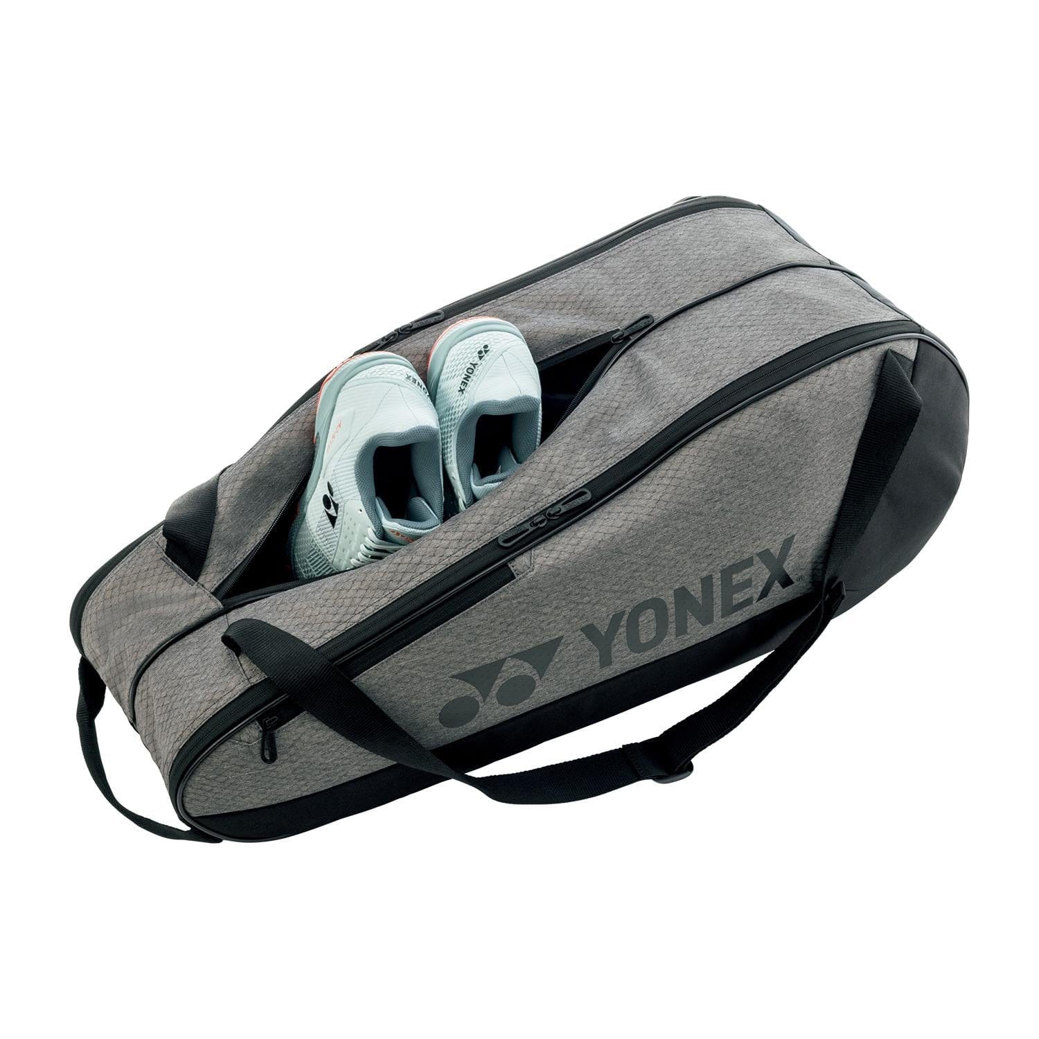 A partially unzipped Yonex 42526EX Team 6 Badminton Bag in grey with black accents reveals light blue athletic shoes inside. Designed for sports gear, it offers two handles and a shoulder strap.