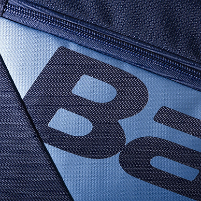 Close-up of a navy blue fabric with a zipper partially visible, mimicking the Babolat RH12 Pure Drive Gen11 12 Racket Bag. The textured material shows partial "Ba" letters in black on the lighter blue section, reflecting the sleek style of this Babolat badminton bag.