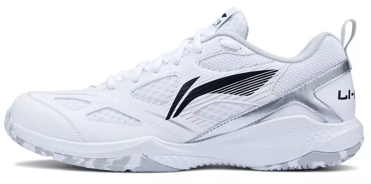 The Li-Ning Blast JF-01 Lite Unisex Badminton Shoes in white feature silver accents, a black swoosh-style design, mesh panels, textured soles for performance on court, and the Li-Ning brand name on the heel.