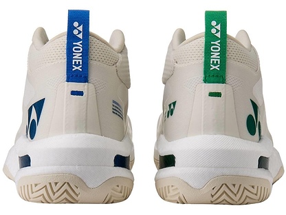 Rear view of Yonex Power Cushion GRPHT THRTTL Concept men's badminton shoes in off-white; left shoe with blue heel tab, right with green. Both feature Yonex logos, patterns, and advanced Power Graphite technology.