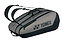 The Yonex 42529EX Team 9 Racket Badminton Bag, in gray and black, features dual shoulder straps and a prominent side logo. Its sleek, elongated design offers high capacity with multiple compartments for carrying sports gear such as rackets.