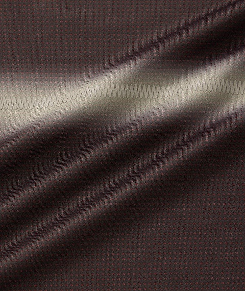Close-up of black fabric from the Yonex 10711YX Crew Neck Men's Badminton T-Shirt, showing a subtle dotted pattern and horizontal zigzag stitching, which highlights the texture and sheen under light.