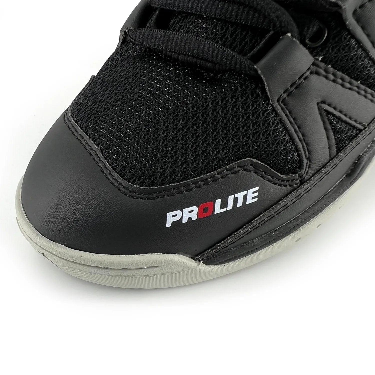 The Karakal KF Pro Lite Badminton Shoes in New Black showcase a close-up of their front, combining mesh fabric with a leather-like material. The shoe is designed for lateral stability and prominently displays "PROLITE" in white and red on the side. It features visible black laces and detailed stitching. The light gray sole is equipped with a shock-absorbing gel insole to enhance comfort.