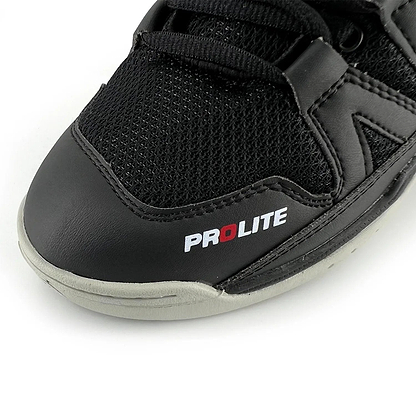 The Karakal KF Pro Lite Badminton Shoes in New Black showcase a close-up of their front, combining mesh fabric with a leather-like material. The shoe is designed for lateral stability and prominently displays "PROLITE" in white and red on the side. It features visible black laces and detailed stitching. The light gray sole is equipped with a shock-absorbing gel insole to enhance comfort.
