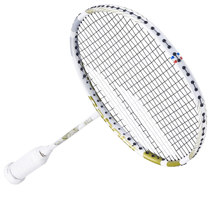 The Babolat Jetstream 74 6U Badminton Racket features a sleek white frame with gold accents and a shot optimizer for enhanced performance. Tightly woven strings and red-blue markings enhance its elegant design, making it a standout choice.