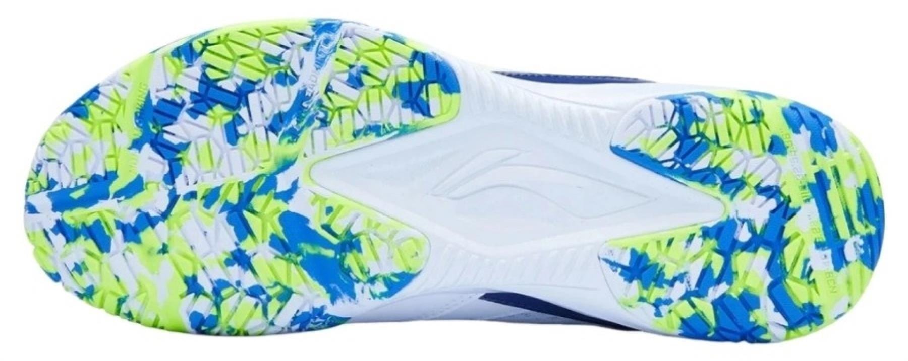 The image displays the sole of the Li-Ning Blast JF-01 Lite Unisex Badminton Shoes in white, blue, and green, with a non-marking outsole featuring a multi-color tread pattern, textured grip, and a raised Li-Ning logo at the center.