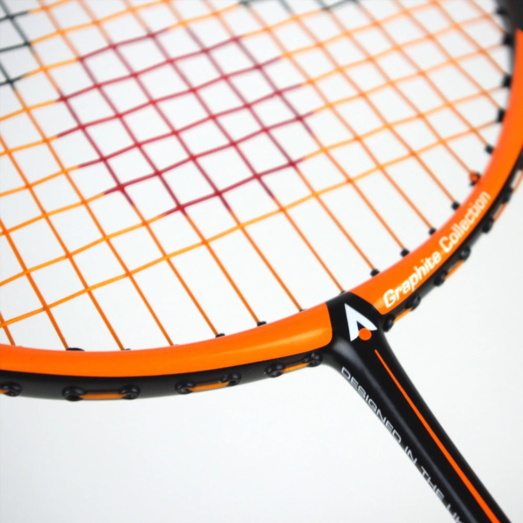 Close-up of the Karakal Black Zone BZ 30 2.1, featuring an orange frame and multicolored strings. The sleek graphite design is modern, akin to a tennis racket. Text on the frame reads "Graphite Collection." Displayed on a plain white surface.