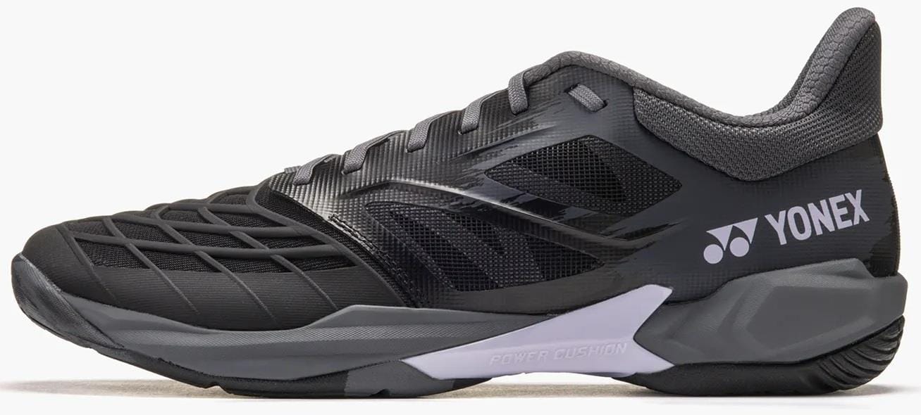 The Yonex Power Cushion Cascade Drive 3 Unisex Badminton Shoes in Black/Grey are shown from the side, featuring a textured upper, cushioned sole with Yonex Power Cushion, and the white Yonex logo near the heel.
