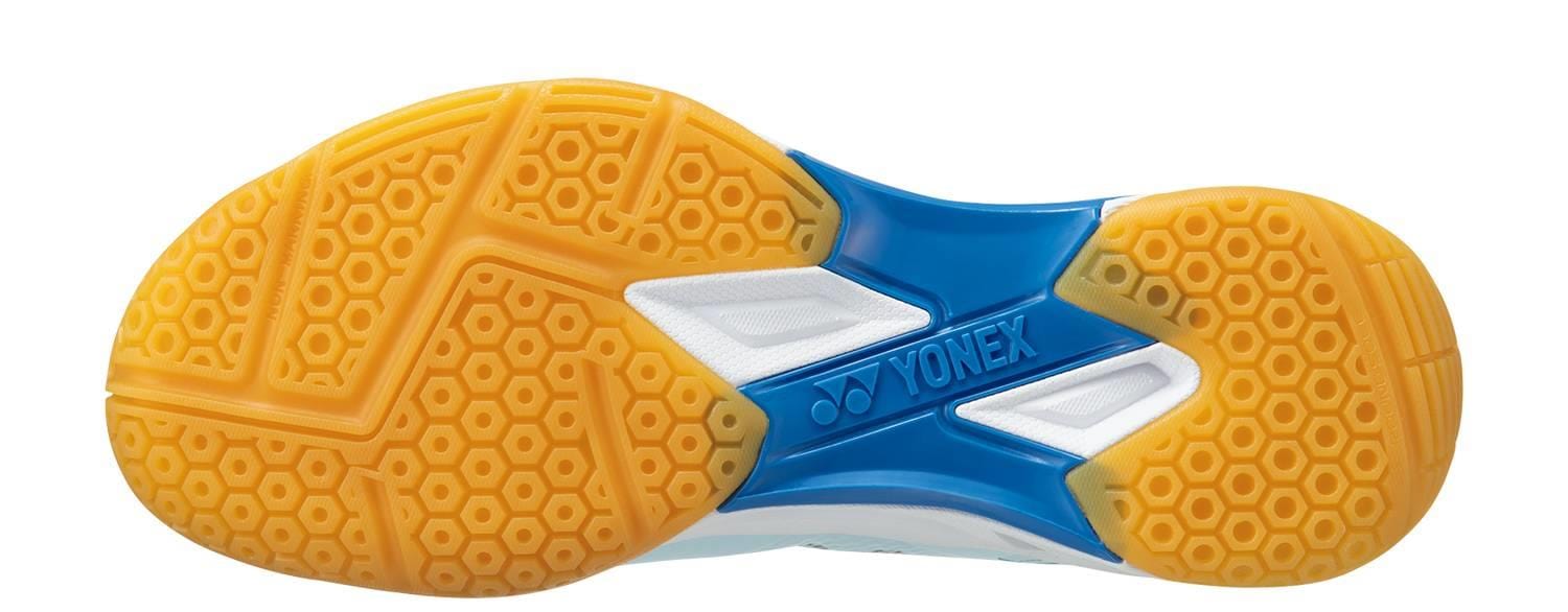 The image shows the sole of Yonex Power Cushion Eclipsion X3 Unisex Badminton Shoes in light blue, featuring a yellow honeycomb tread, blue midsection, and white accents—designed for indoor courts with Yonex’s Power Cushion technology.