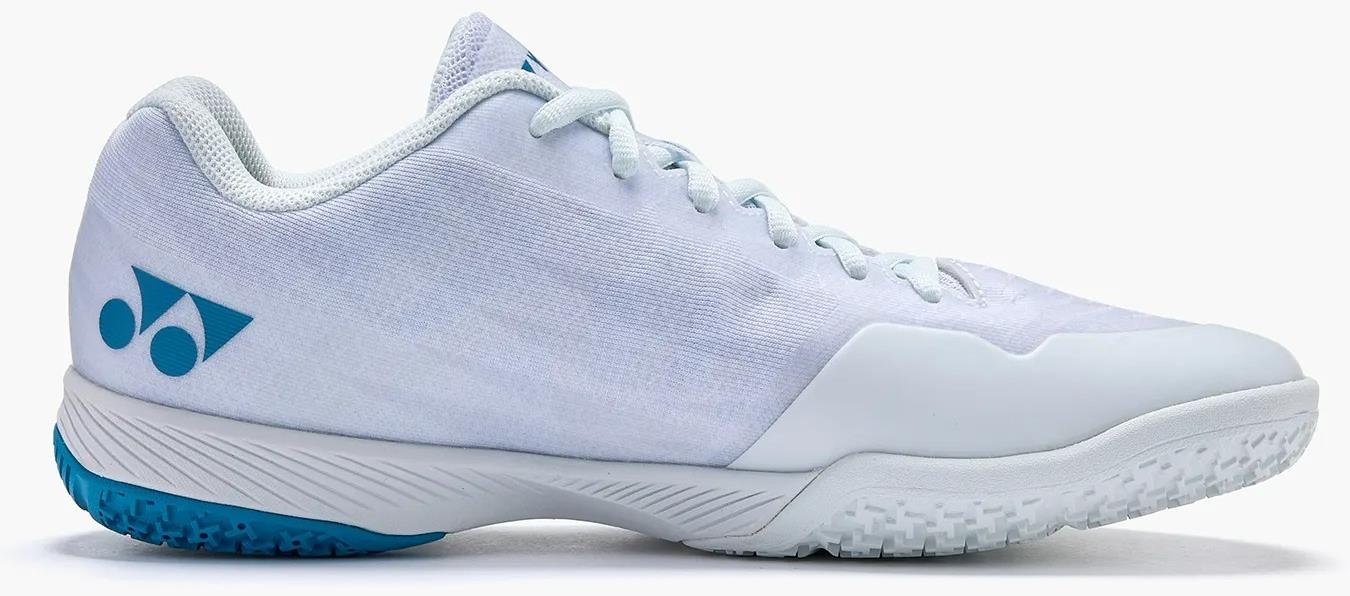 The Yonex Power Cushion Aerus Z2 Mens Badminton Shoes, shown from the side on a plain white background, feature a low-cut white design with light blue accents, textured sole, and white laces.
