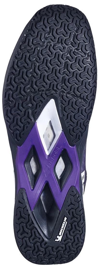 The image displays the black outsole of Babolat Shadow Tour 5 Men's Badminton Shoes (Black/Purple), featuring a herringbone tread, purple and white midsole accents, and the Michelin logo—perfect for indoor courts.