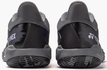 The Yonex Power Cushion Cascade Drive 3 Unisex Badminton Shoes in black and grey feature textured soles and the Yonex logo on the heels, offering comfort and performance—ideal for badminton enthusiasts.