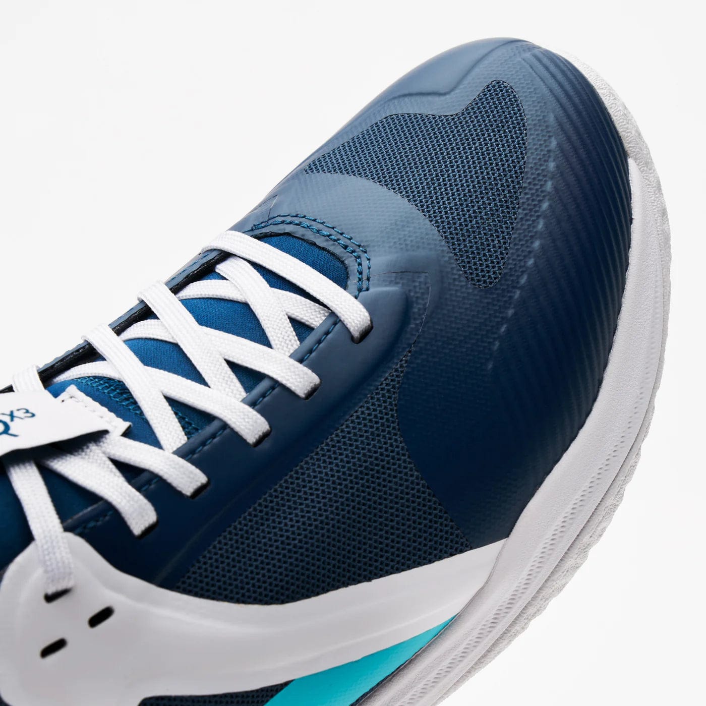 A close-up of the Kanso Equilibrium EQx3 Unisex Badminton Shoe in navy shows white laces and sole. It features a textured mesh, light blue accent, and Speedlight foam for stability and agility, with the toe angled toward the bottom left corner.
