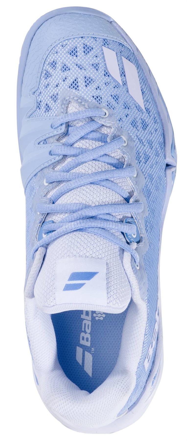 A top-down view of the Babolat Shadow 4 Womens Badminton Shoes - Snow Blue by Babolat, showing light blue mesh fabric, white laces, geometric upper patterns, and branded logos on the tongue and side.