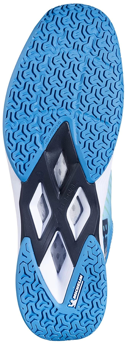 Close-up of the blue and white textured sole of the Babolat Shadow Tour 5 Mens Badminton Shoes - Algier Blue, by Babolat, showing geometric tread patterns and two black diamond-shaped cutouts for improved indoor court grip.