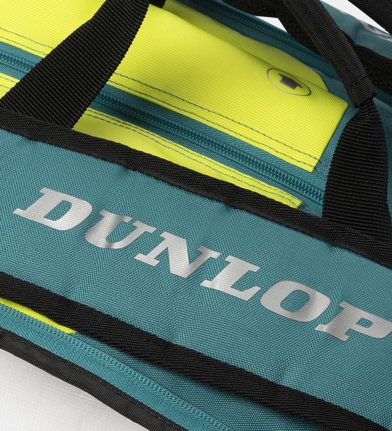 Close-up of the Dunlop SX Performance 12 Racket Badminton Bag displaying "DUNLOP" branding. It features a teal and yellow design with black zippers and ergonomic shoulder straps for comfort.