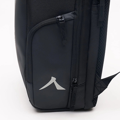 Close-up of a black Kanso Intuko Badminton 23L Backpack showing two zippered compartments. The lower one has a reflective arrow logo. With visible stitching and textured side panels, this durable companion by Kanso is ideal for any adventure.