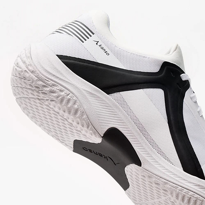 The Kanso Equilibrium EQx3 Unisex Badminton Shoes in white and black showcase a textured sole and layered design. "Kanso" is printed on the side, with geometric black accents, striped details on a white background, and Speedlight Foam for shock absorption, enhancing agility.