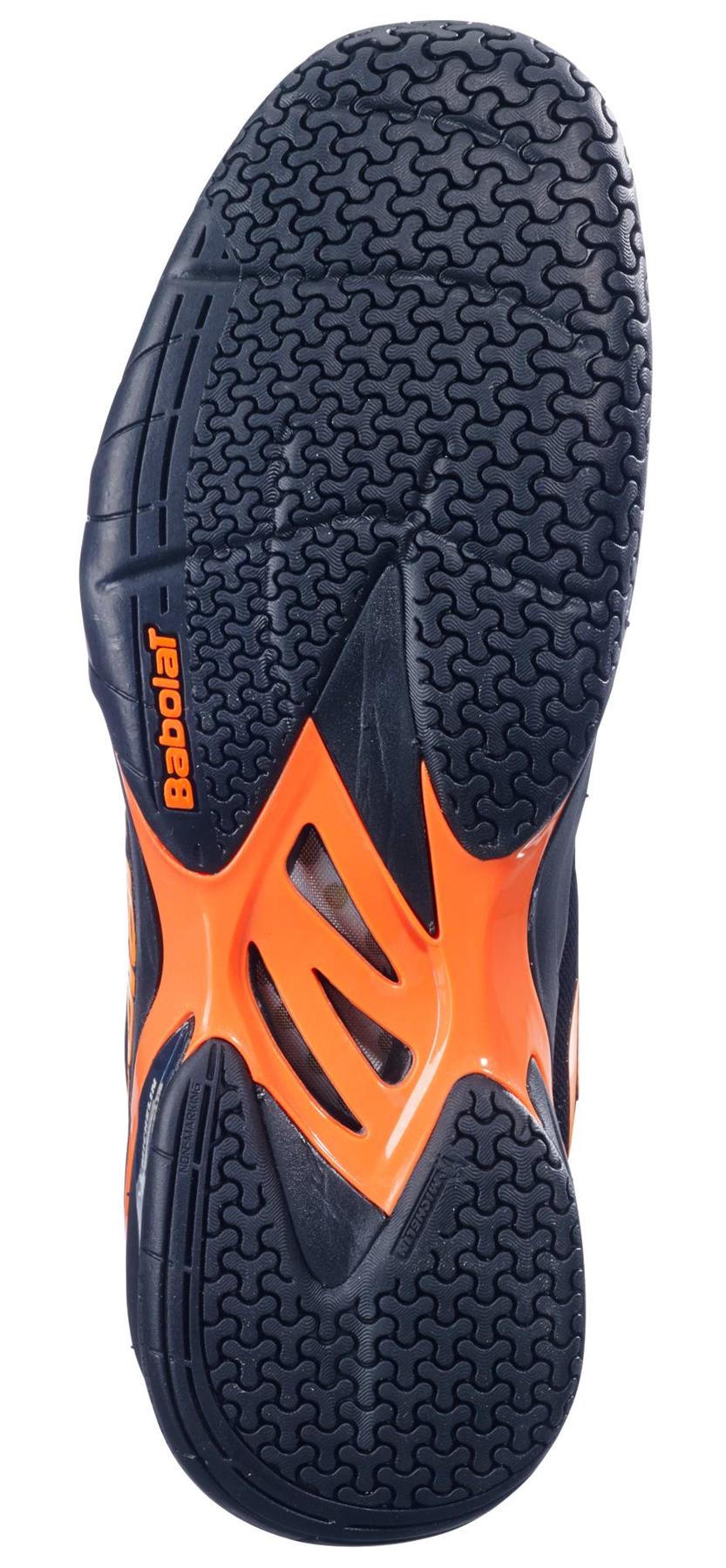 The image shows the black and orange sole of the Babolat Shadow 4 Mens Badminton Shoes, featuring a herringbone tread pattern for grip and the "Babolat" brand name on the side.