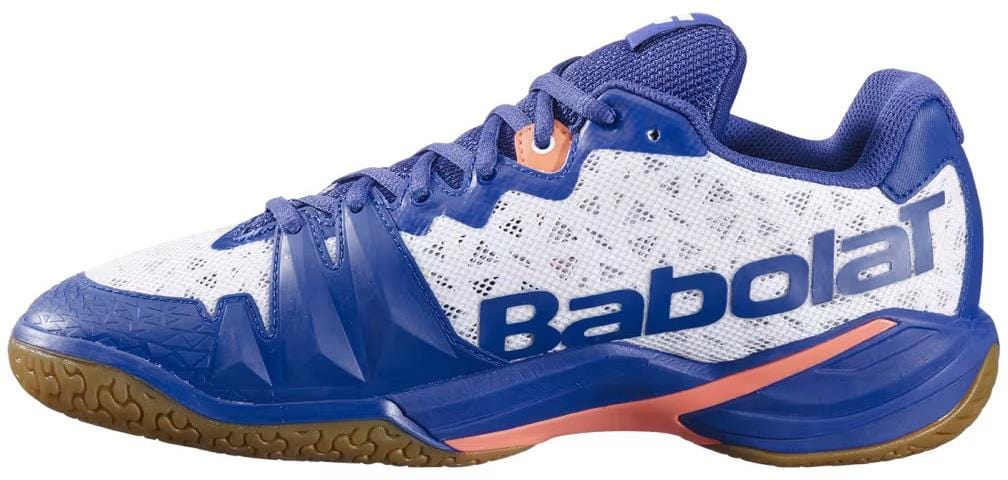 The Babolat Shadow 4 Men's Badminton Shoes in White/Blue/Navy feature a gum sole, mesh upper, and signature "Babolat" branding—designed for top indoor sports performance.