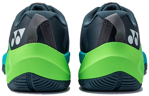 Rear view of the Yonex Subaxia GT WIDE 2026 Unisex Badminton Shoes in Dark Green, displaying black, gray, green, and blue accents. The white Yonex logo appears on the heel with a textured outsole for grip and Power Cushion Rev technology.