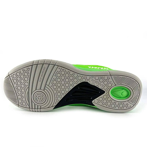 The image displays the sole of the Karakal KF Pro Lite Badminton Shoes in green, ideal for badminton enthusiasts. It features hexagonal and circular tread patterns for lateral stability, with text that reads "NON MARKING" and "KARAKAL KF ProLite." A small logo embellishes the heel area.