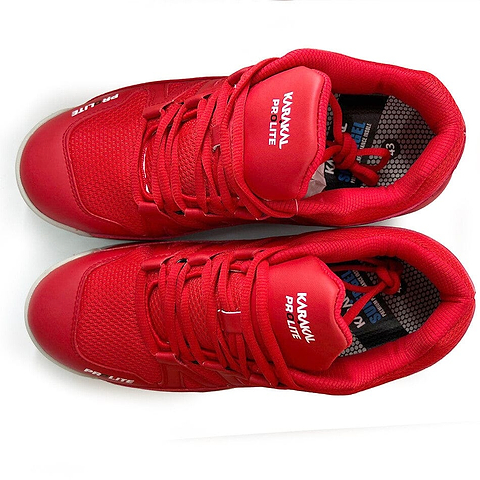 A pair of vibrant new red sneakers with white accents, featuring the brand name "Karakal" prominently on the tongue and side. Emphasizing their lateral stability, these Karakal KF Pro Lite Badminton Shoes also include a shock-absorbing gel insole for enhanced comfort. Ideal for those looking for both style and support.