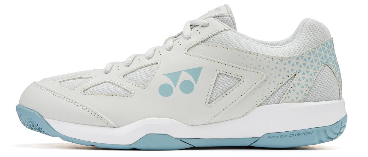 The Yonex Power Cushion Strider Ray Unisex WIDE Badminton Shoes in Blue Grey feature a low-top, wide fit with mesh and leather panels, blue geometric accents, and a logo—ideal for all-day comfort on or off the court.