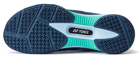 The image displays the sole of the Yonex Power Cushion 88 Dial 3 Wide Unisex Badminton Shoes in Navy / White by Yonex. The sole features a navy blue base with light blue and teal accents, showcasing textured patterns for enhanced grip. Specifically designed as a wide badminton shoe, it incorporates the advanced BOA Fit System for a secure and customizable fit. The Yonex logo appears prominently at the center of the sole.