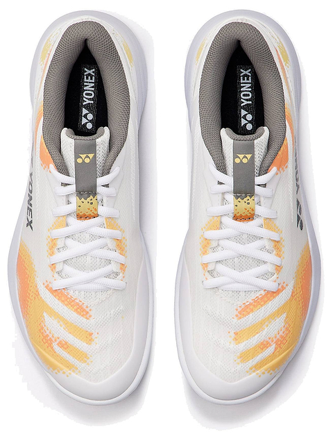 A pair of Yonex Power Cushion Cascade Accel unisex badminton shoes in white and orange, featuring white laces, a white base, and orange and yellow accents. Viewed from above, this intermediate shoe model offers the Yonex Power Cushion for improved comfort and shock absorption, with the Yonex logo displayed on the tongue and inner sole of both shoes.