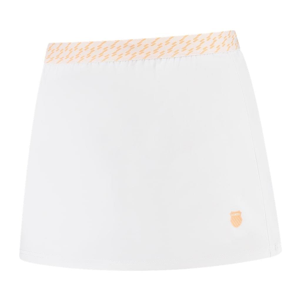Introducing the K-Swiss Hypercourt Women's Badminton Skirt 5 in White: This athletic skirt showcases a subtle light orange zigzag pattern on the waistband. Designed for maximum comfort with its 4-Way Density Stretch, it features an integrated legging short and is adorned with a small orange shield logo at the bottom right corner.