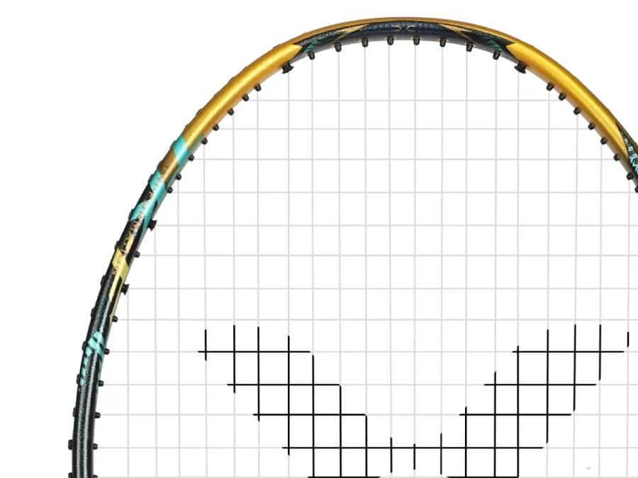 Close-up of the top half of the Victor Thruster F C Ultra X Badminton Racket by Victor, showcasing its gold and black frame with white strings and a head heavy balance, set against a plain white background.