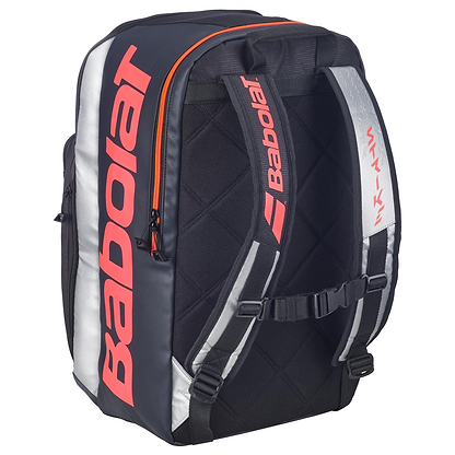 The Babolat Pure Strike Tennis Backpack - Carbon Grey features red accents, large Babolat logos, padded shoulder straps, and a chest buckle—ideal as a durable sports bag for tennis players.