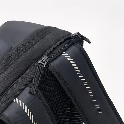 Close-up of a Kanso Intuko Badminton 23L Backpack in Black, featuring a zippered pocket and padded shoulder straps with striped design. Its textured fabric makes it the perfect everyday companion against a plain white background.