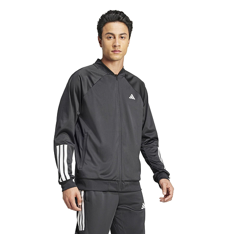 A person is wearing a black ADIDAS Men's 3 Stripe Knit Badminton Jacket with white sleeve stripes, a zipper, and a small chest logo, standing against a plain white background.