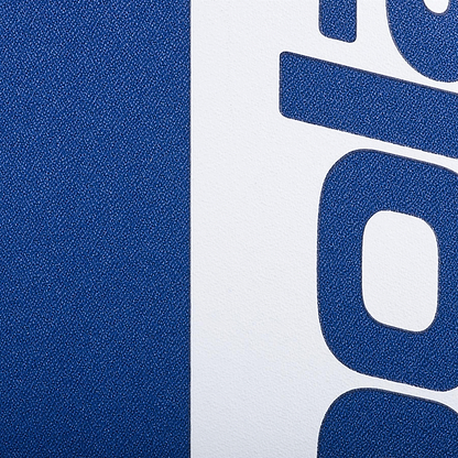 Close-up of the Babolat Court Hero Badminton Backpack - Dark Blue by Babolat, showing its textured recycled PET blue surface beside a white section with bold blue lettering and the curved lower part of a letter "g.