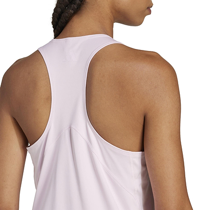 A person with braided hair is seen from behind, wearing the ADIDAS Women's Club Badminton Tank Top in pink. Made from recycled materials, it features a racerback and CLIMACOOL technology for exceptional comfort.