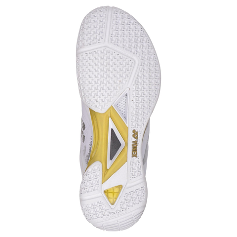 The image features the sole of Yonex Power Cushion Eclipsion Z3 Men's Badminton Shoes in White/Gold, displaying a textured grip with geometric shapes and a logo near the heel, emphasizing enhanced cushioning for improved performance.