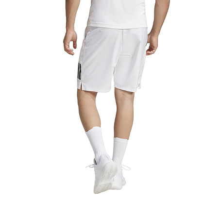 A person in a white athletic outfit walks away from the camera wearing ADIDAS Men's 3 Stripe Badminton Shorts, featuring moisture-wicking recycled materials. They sport white socks and shoes, with part of a black stripe visible on their shorts.